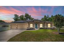 Beautiful single Gathering home featuring a well maintained lawn, solar panels, and a three car garage at 475 Pitt St, Clermont, FL 34711