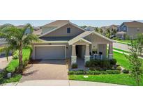 Beautiful single-Gathering home featuring a brick driveway, manicured lawn, and covered front porch at 5052 Blanchard Ct, St Cloud, FL 34772