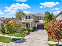 Beautiful two-story home with a well-manicured lawn, mature trees, and a spacious driveway at 7945 Pleasant Pine Cir, Winter Park, FL 32792