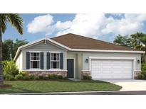 Charming single-story home with a well-manicured lawn, stone accents, and a two-car garage at 912 Pearlwood Loop, Eagle Lake, FL 33839
