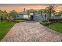 Beautiful home featuring a brick driveway, manicured landscaping and mature palm trees at 10543 Woodchase Cir, Orlando, FL 32836