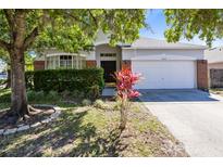 Charming single-story home featuring a well-maintained lawn and attractive landscaping with mature trees at 14230 Sunriver Ave, Orlando, FL 32828