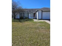 Charming single-story home featuring a well-maintained lawn, attached garage, and a welcoming entrance at 1510 Massa St, Kissimmee, FL 34744