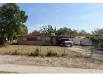 Single-story home with a carport, fenced yard, and compact landscaping under a bright blue sky at 1515 Lady Ave, Ocoee, FL 34761