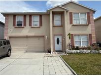 Two-story home featuring an attached two-car garage, small front yard, and neutral color palette at 3024 Natoma Way, Orlando, FL 32825