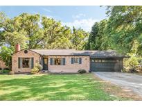 Charming single-story brick home with a well-maintained lawn, large trees and attached garage at 718 31St St, Orlando, FL 32805