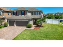 Charming two-story home featuring a manicured lawn, brick driveway and a two-car garage at 753 Sandy Bar Dr, Winter Garden, FL 34787
