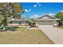Charming single-story home with a well-maintained lawn and attached two-car garage, perfect for suburban living at 8703 Grandee Dr, Orlando, FL 32829