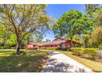 Charming home featuring a long driveway, mature trees, and well-maintained landscaping at 160 Archers Pt., Longwood, FL 32779