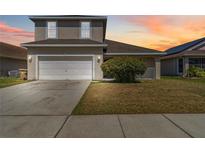Charming two-story home featuring a two-car garage, well-maintained lawn and beautiful sky at 2723 Callaway Ln, Kissimmee, FL 34744