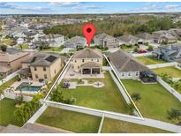Aerial view of property featuring a large backyard with a patio, fire pit, and well-manicured lawn at 3087 Somerset Park Dr, Orlando, FL 32824