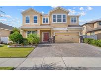 Inviting two-story home with a brick driveway and manicured landscaping under a blue sky at 3087 Somerset Park Dr, Orlando, FL 32824