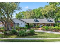 Charming single-story home with a brick and siding exterior, dormer windows and mature landscaping at 420 Wild Oak Cir, Longwood, FL 32779