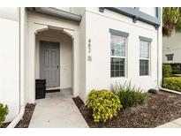 Townhome front entrance with grey door, manicured landscaping, and house number at 482 Captiva Dr, Davenport, FL 33836