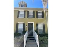 Townhouse exterior features a private entrance with black door, white rails, three windows, and black shutters at 6274 Bristol Channel Way, Orlando, FL 32829