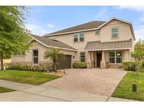 Charming two-story home featuring a brick driveway, stone accents and meticulously landscaped front yard at 12002 Angle Pond Ave, Windermere, FL 34786