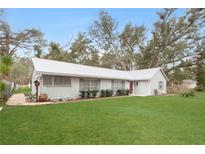 Charming single-story home featuring a well-manicured lawn and a screened porch at 1704 15Th St, Orange City, FL 32763