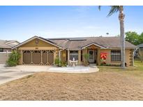 Charming single-story home with a two car garage, solar panels, and a welcoming front patio and lawn at 1969 La Rue Ave, Deltona, FL 32725