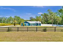 Charming home with a blue exterior, a white metal roof, and a well-kept yard with a black fence at 245 Country Circle E Dr, Port Orange, FL 32128