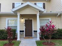 Inviting condo entrance with a well-maintained lawn, covered porch, and attractive front door at 2964 Lucayan Harbour Circ # 106, Kissimmee, FL 34746