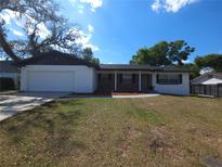 Charming one-story home featuring a well-maintained lawn and attached two-car garage at 3504 Portersfield Rd, Orlando, FL 32808