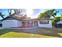Charming one-story home featuring a well-manicured lawn and front porch at 3504 Portersfield Rd, Orlando, FL 32808