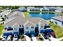 Beautiful townhomes featuring garages, driveways, and a scenic pond in a well-maintained community at 4512 Sparkling Shell Ave, Kissimmee, FL 34746