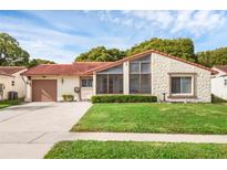 Charming single-story home with well-maintained lawn, stone exterior, and red tile roof at 10607 Whitman Cir, Orlando, FL 32821