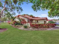 Charming villa featuring a red tile roof, lush landscaping, and a well-manicured lawn in a vibrant setting at 112 Coventry Ln, Haines City, FL 33844