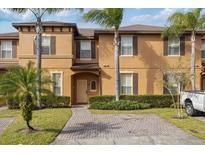 Charming two-story townhome with lush landscaping and paved driveway at 3132 Calabria Ave, Davenport, FL 33897