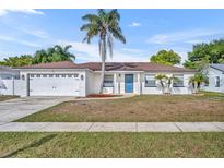 Charming single-story home featuring a bright blue front door, and a well-maintained front yard with mature landscaping at 3236 Kayenta Ct, Orlando, FL 32829