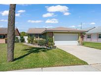 Charming single-story home features a well-manicured lawn and an attached two-car garage at 335 Kantor Blvd, Casselberry, FL 32707