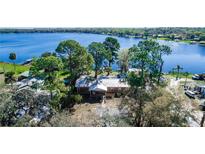 Aerial view of a cozy lake house nestled among lush trees near a serene lake at 36112 Lake Unity Rd, Fruitland Park, FL 34731