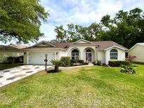 Charming single-story home with a well-manicured lawn and decorative front garden at 4638 River Ridge Dr, Leesburg, FL 34748