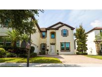 Charming two-story home with a brick driveway, manicured lawn, and lush landscaping at 6008 Golden Dewdrop Trl, Windermere, FL 34786