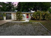 Charming single-story home featuring a red front door and a well-maintained, rock landscaped front yard at 6031 W Ridgewood Ave, Orlando, FL 32835
