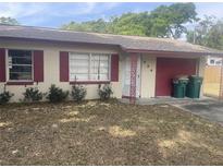 Charming single-story home with a red-trimmed roof, attached garage, and small front yard at 904 Hickory Ave, Fruitland Park, FL 34731