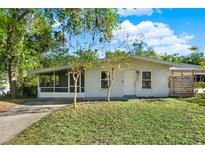Charming single-story home featuring a screened porch and well-maintained front yard with mature trees at 1179 Seminole St, Clermont, FL 34711