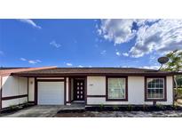 Charming single-story home with white siding, brown trim, and a well-maintained front yard at 1232 Roma Ct, Orlando, FL 32825