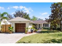 Charming one-story home with a well-manicured lawn, a driveway, and an attached garage at 1564 Cavendish Rd, Winter Park, FL 32789