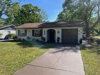 Charming single-story home featuring a brown roof, well-kept lawn, and a paved driveway at 2617 S Marshall Ave, Sanford, FL 32773