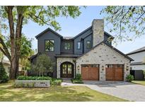 Beautiful exterior elevation showcasing stone accents, a two-car garage, and lush landscaping at 2814 Parkland Dr, Winter Park, FL 32789
