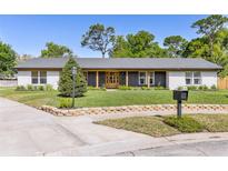 Charming single-story home with beautifully landscaped front yard, updated paint, and inviting entrance at 400 Royal Palm Ct, Longwood, FL 32779