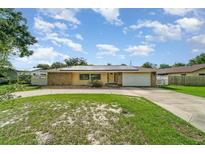 Charming ranch style home with stone accents, solar panels and a well manicured circular driveway at 690 S Lakemont Ave, Winter Park, FL 32792