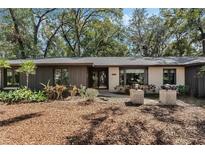 Charming single-story home featuring a brick and wood facade, with lush landscaping at 9676 Wild Oak Dr, Windermere, FL 34786