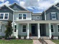 Charming townhome featuring two-tone siding, a welcoming porch, and manicured landscaping at 13532 Autumn Harvest Ave, Winter Garden, FL 34787