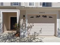 Charming townhome featuring a one car garage and welcoming front door at 13832 Dove Wing Ct, Orlando, FL 32828
