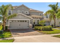 Charming two-story home featuring a three-car garage, beautifully landscaped yard, and well-maintained exterior at 1395 Olympic Club Blvd, Champions Gate, FL 33896