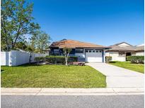 Charming single-story home featuring a well-manicured lawn, a driveway, and a single car garage at 2656 Autumn Green Dr, Orlando, FL 32822
