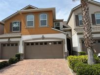Two-story home featuring an attached two-car garage and a red brick driveway at 3665 Brighton Park Cir, Orlando, FL 32812